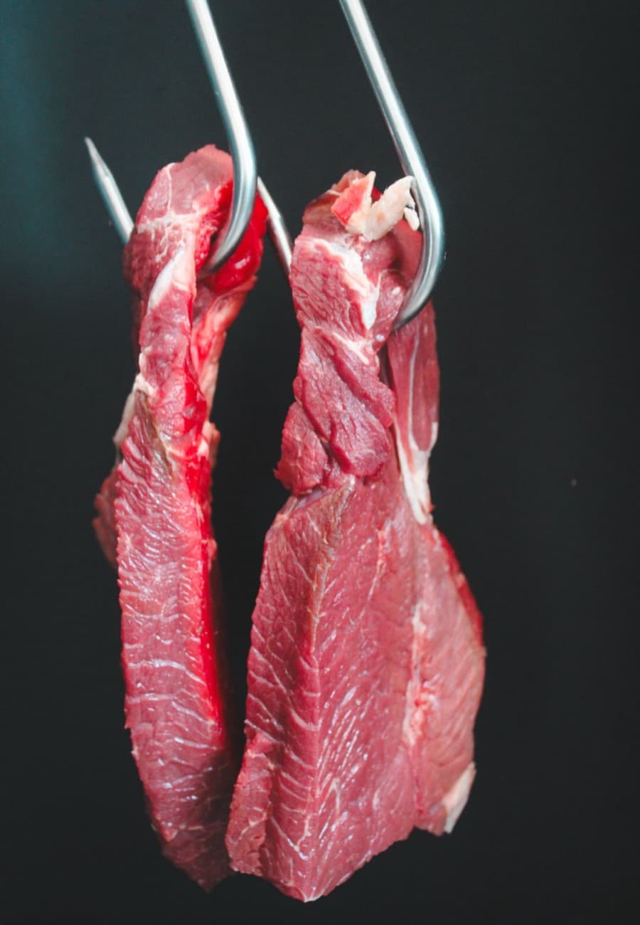 Tagli di carne bovina appesi in macelleria